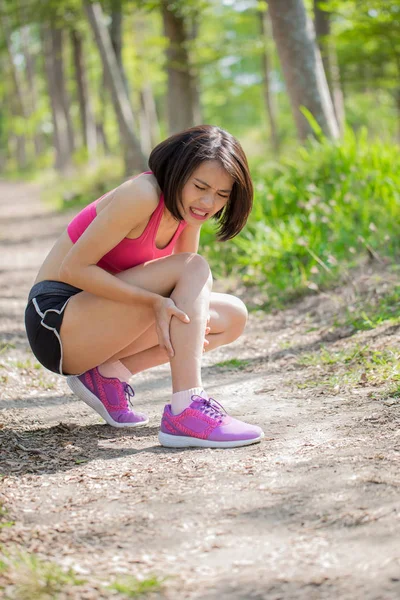 sport woman feeling  pain with calf strain in the forest