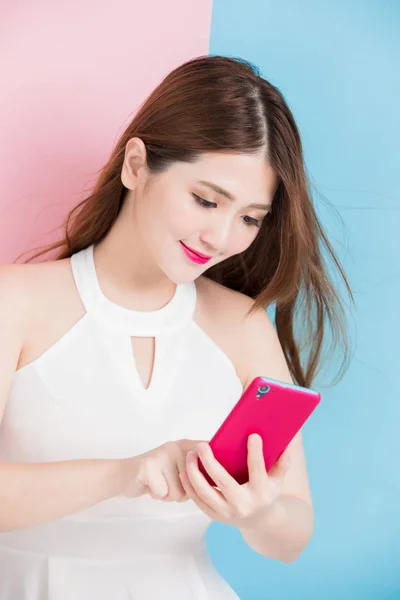 Uma Menina Bonita Usando Smartphone Isolado Fundo Rosa Azul — Fotografia de Stock