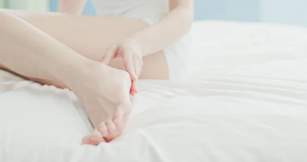 beauty woman applying cream on  feet at home