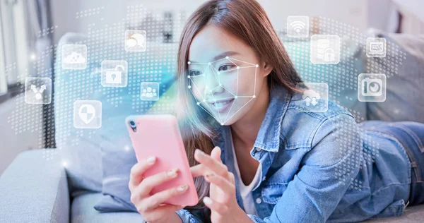 Young Woman Holding Smart Phone Scanning Facial Recognition Lying Sofa — Stock Photo, Image