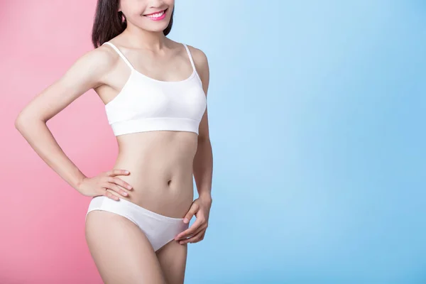 woman showing  her thin waist with blue and pink background