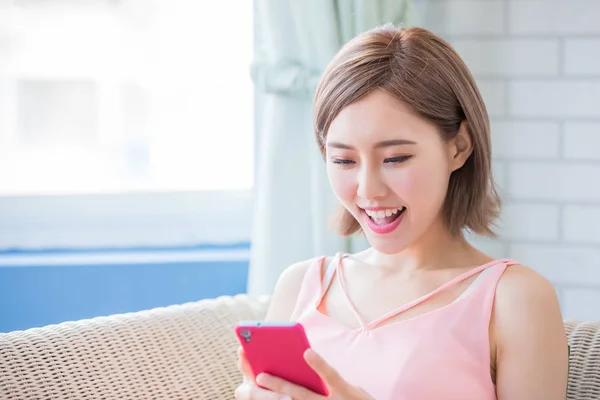 Mujer Sentada Sofá Usando Teléfono Felizmente Casa —  Fotos de Stock