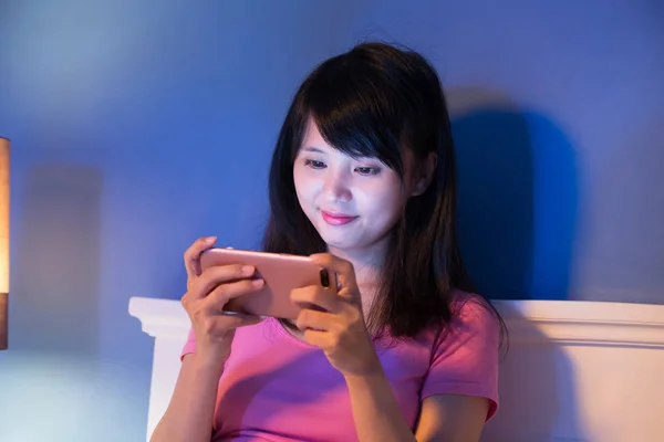 晚上在床上玩手机游戏的女人 — 图库照片