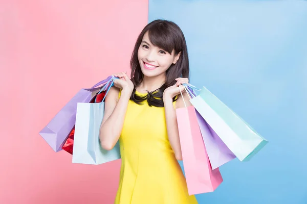 青色とピンク色の背景に買い物袋を持つ女性 — ストック写真