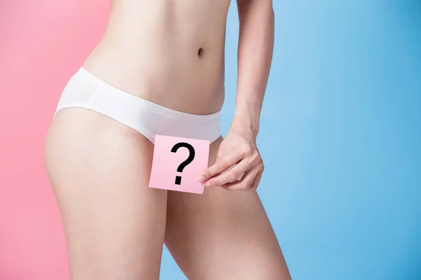 woman with  question mark.  laser hair removal  concept on the blue and pink background