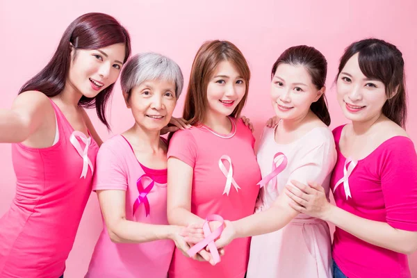 女性はピンクのリボンを表示します ピンク色の背景に乳がん予防 — ストック写真