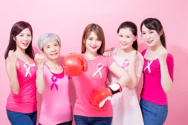 女性はピンク色の背景に乳がん予防に手袋を着用します — ストック写真