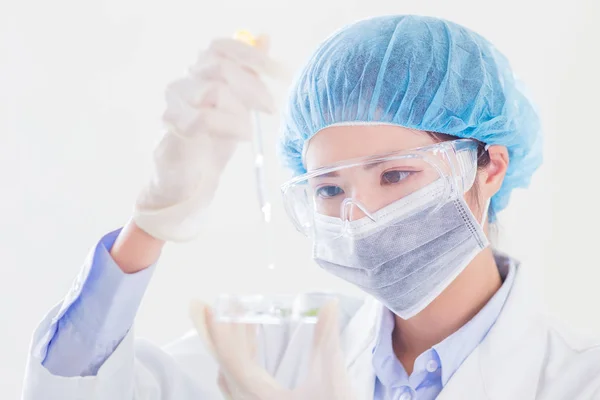 女性科学者が研究室でペトリ皿と植物を取る — ストック写真