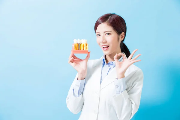 Mujer Dentista Tomar Diente Implante Mostrar Usted Fondo Azul —  Fotos de Stock