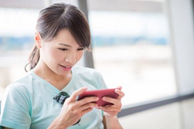 woman use phone and play mobile game in the Station clipart