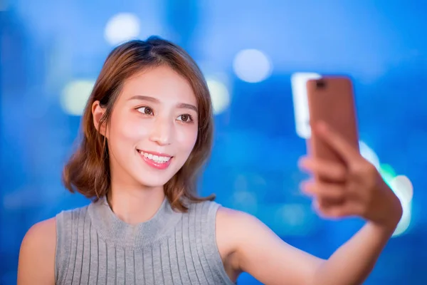 女性使用電話と喜んで夜 Selfie — ストック写真