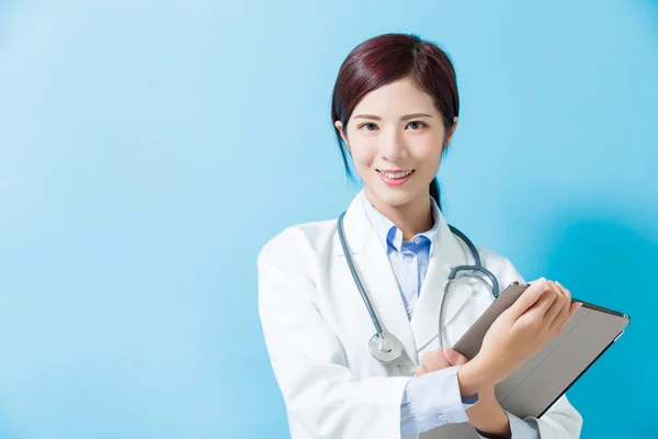 Ärztin Lächelt Sie Und Nimmt Tablet Auf Blauem Hintergrund — Stockfoto