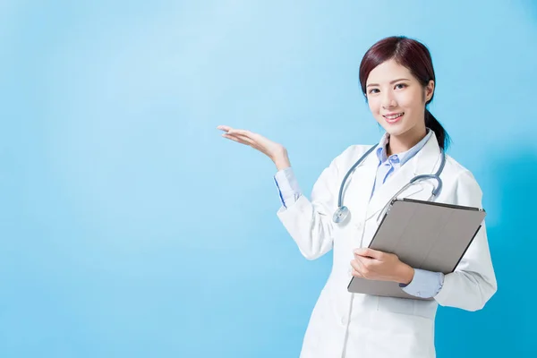 Ärztin Zeigt Etwas Und Nimmt Tablet Auf Blauem Hintergrund — Stockfoto