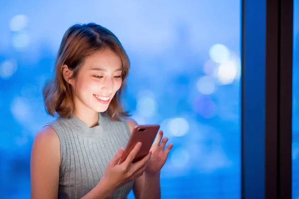 Vrouw Gebruik Telefoon Gelukkig Thuis Avond — Stockfoto