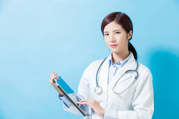 Ärztin Lächelt Sie Und Nimmt Tablet Auf Blauem Hintergrund — Stockfoto