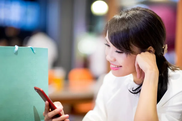 Kvinne Bruker Telefon Med Glede Med Sin Handlepose Restauranten – stockfoto