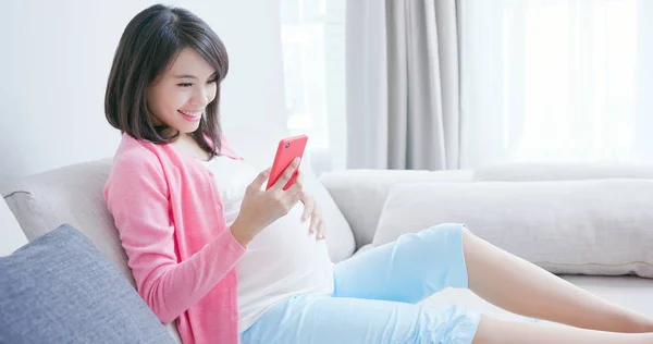 Беременная Женщина Использует Смартфон Сидеть Диване — стоковое фото