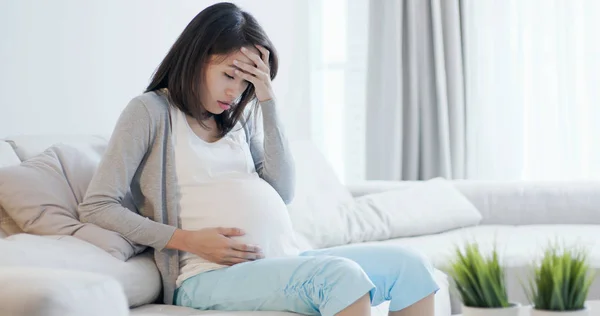 임신한 여자는 소파에 앉아서 집에서 우울증을 — 스톡 사진