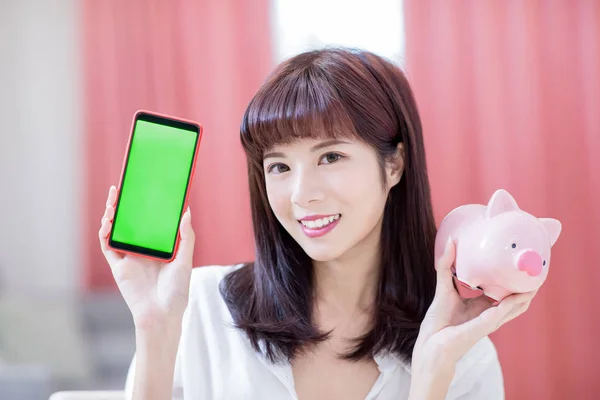 Щаслива Жінка Показує Свій Рожевий Скарбничка Смартфон Зеленим Екраном — стокове фото