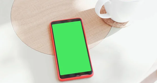smart phone with green screen in the cafe