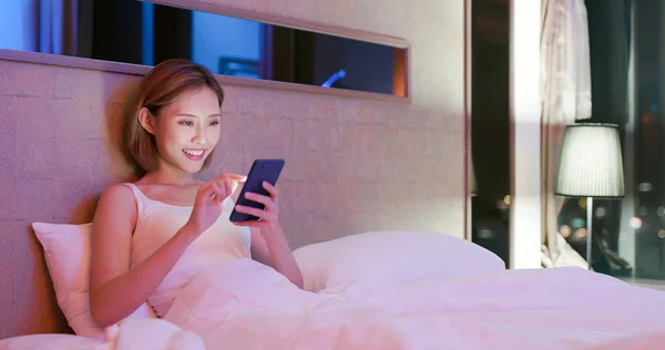 Nő a telefon használata ágyon — Stock Fotó
