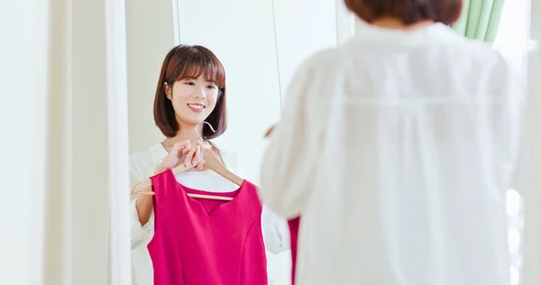 Asiático chica tratando de vestir felizmente — Foto de Stock