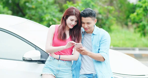 Couple utilisent téléphone avec voiture — Photo