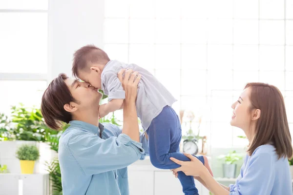 Happy family kiss their child — Stock Photo, Image