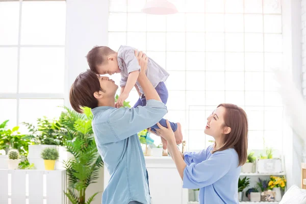 Glückliche Familie küsst ihr Kind — Stockfoto