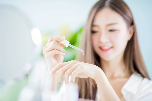 Mujer dejando caer crema hidratante de colágeno —  Fotos de Stock