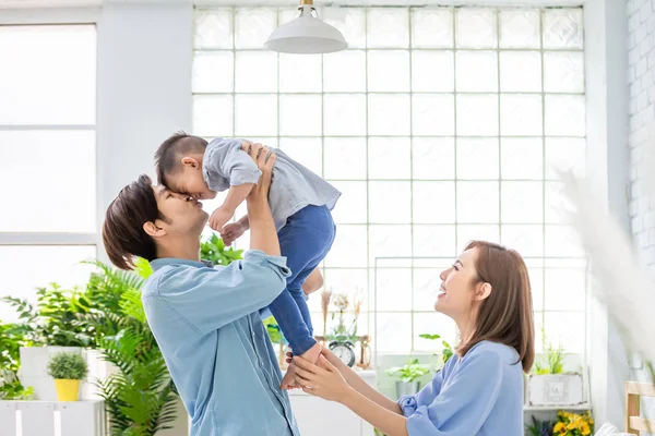 Счастливая семья целует своего ребенка — стоковое фото