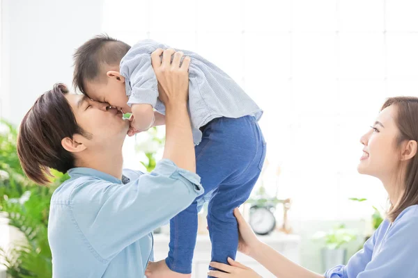 Família feliz beijar seu filho — Fotografia de Stock