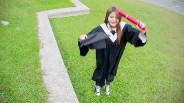 Girl gratuate jump high happily — Stock Video