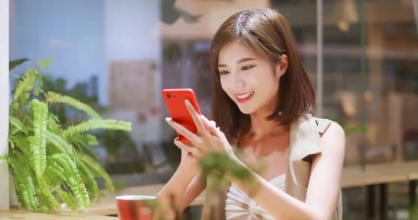 Mujer joven usa el móvil felizmente — Vídeos de Stock