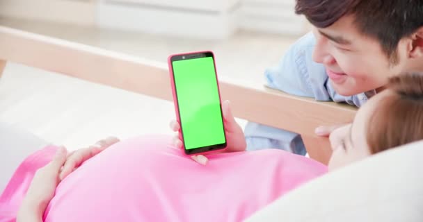 Zwangere paar tonen groen scherm — Stockvideo