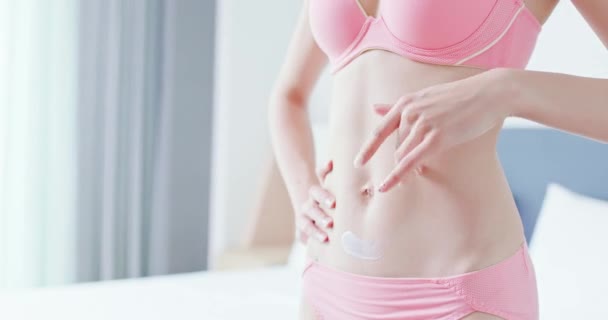 Kvinna applicera lotion på magen — Stockvideo