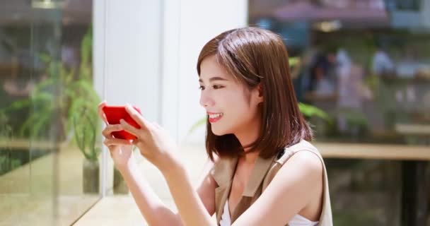 Молодая женщина играет в мобильные игры — стоковое видео