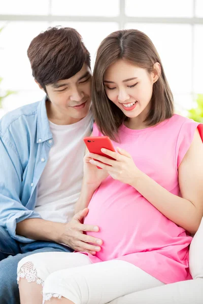 怀孕的夫妇使用智能手机 — 图库照片