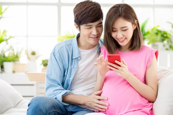 Embarazada pareja uso inteligente teléfono — Foto de Stock