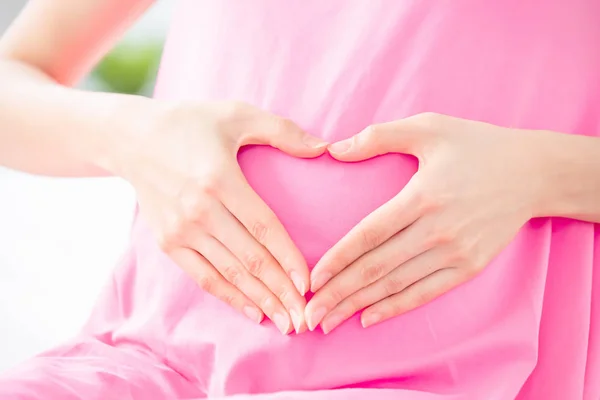 Pregnant woman show love gesture — Stock Photo, Image