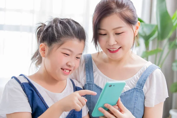 Córka i matka używać smartphone — Zdjęcie stockowe