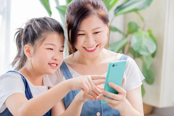 Дочка і мати використовують смартфон — стокове фото