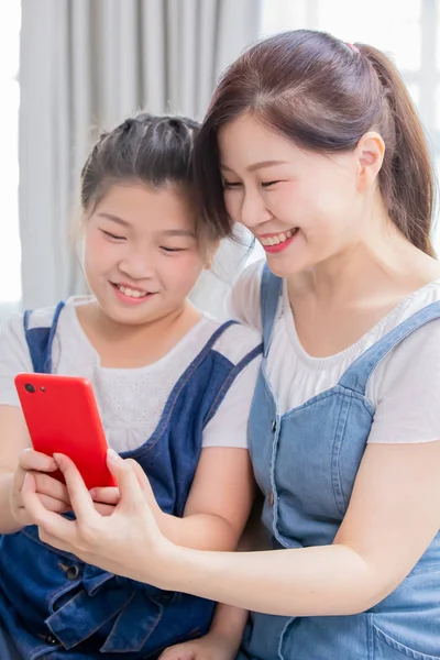 Tochter und Mutter nutzen Smartphone — Stockfoto