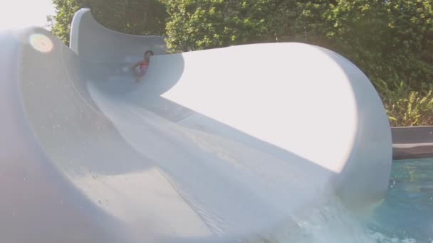 Asiatische Mädchen spielen auf waterslide — Stockvideo