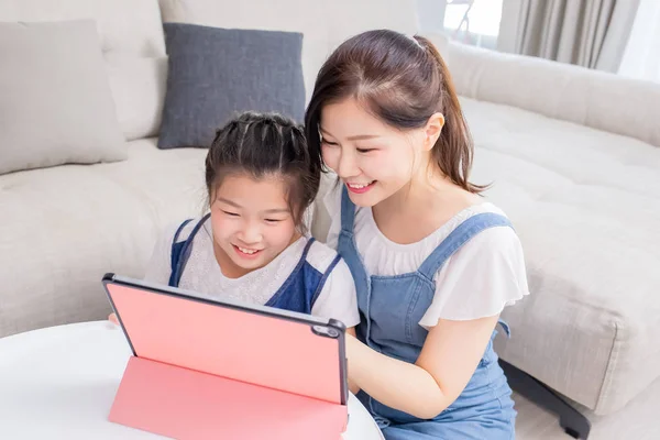 Maman et fille utilisent la tablette heureusement — Photo