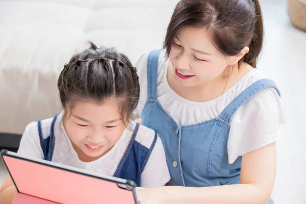 Mãe e filha usam tablet — Fotografia de Stock