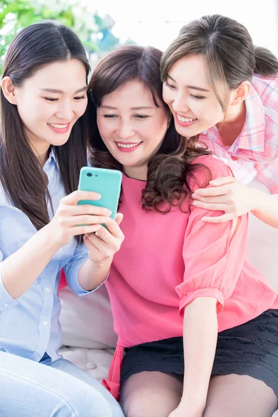 Daughters and mother use smartphone — Stock Photo, Image