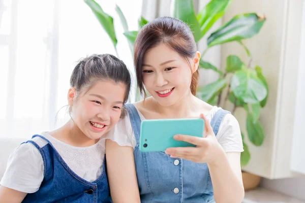 Dcera a máma používají smartphone — Stock fotografie