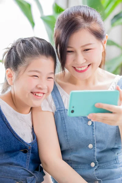 Daughter and mom use smartphone — Stock Photo, Image