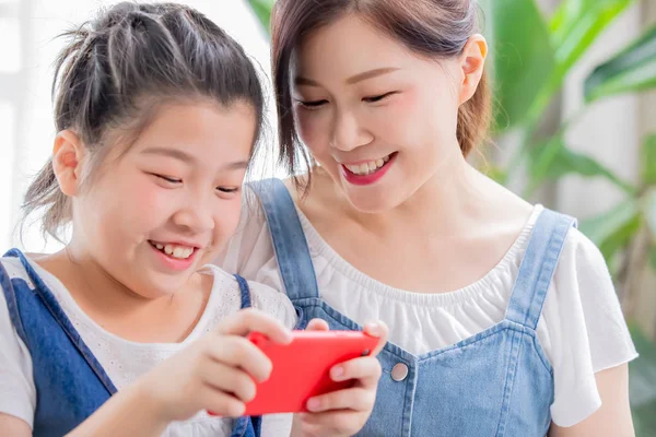 Дочка і мама грають в мобільну гру — стокове фото